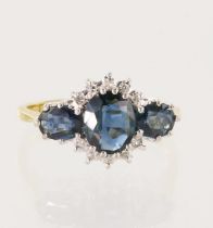 18ct yellow gold diamond and teal sapphire trilogy cluster ring, principle oval sapphire measures