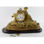 Gilt metal ormolu mantel clock, depicting a boy with a rifle, white enamel dial with Roman numerals,