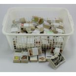 White plastic basket with a large qty of cigarette card sets loose in bundles (Qty)