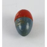 Smallest doll In the World. Blue and red wooden egg with title in gold paint. Complete with doll