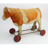 Steiff. A Steiff toy cow on four wheels, circa early 20th Century, with pull cord to back (partially