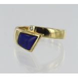 14ct yellow gold contemporary crossover dress ring, set with one 0.015ct diamond and lapis lazuli,