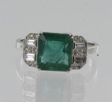 White gold (tests 18ct) diamond and emerald dress ring, one step cut emerald approx. 2.25ct, flanked