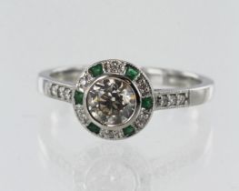 White gold (tests 18ct) diamond and emerald target halo ring, principle round brilliant cut