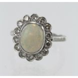 White gold (tests 18ct) opal and diamond cluster ring, one oval cabochon opal measuring approx. 10.