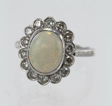 White gold (tests 18ct) opal and diamond cluster ring, one oval cabochon opal measuring approx. 10.