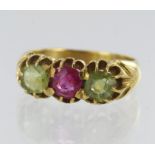 Yellow gold (tests 22ct) synthetic ruby and peridot trilogy ring, syn. ruby measures approx. 6mm,