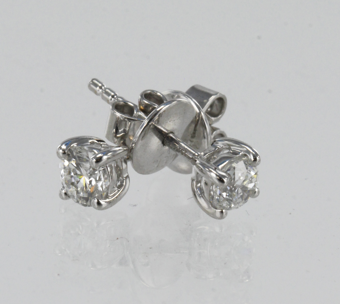A pair of 18ct white gold certificated diamond solitaire stud earrings, one round brilliant cut in