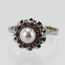 White gold (tests 18ct) pearl and ruby dress ring, one cultured pearl approx. 6mm, surrounded by ten