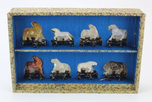 Eight Oriental stone carved horses, each on a wooden stand, height 60mm approx., contained in