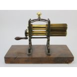 Cast iron and brass crimping machine, circa 19th Century, mounted on a contemporary wooden base,