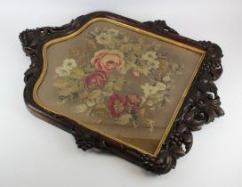 Victorian embroidery depicting flowers, contained in a contemporary carved frame, decorated with