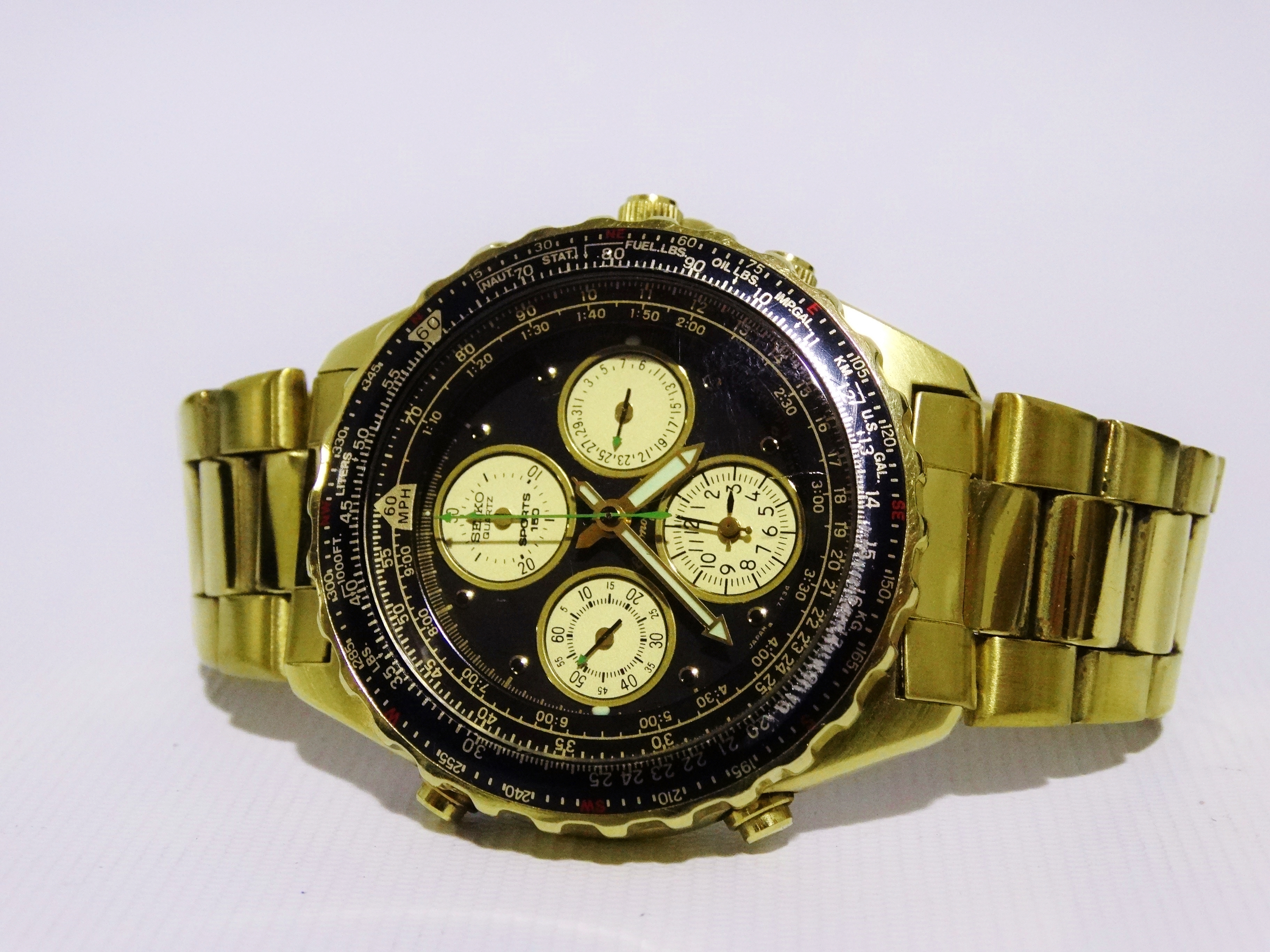 A Seiko Chronograph Rotary Slide Rule Sports 150 - a gilt steel case, the black dial with dots and