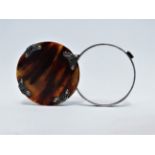 A late Victorian tortoiseshell and white metal mounted magnifying glass - diameter 6cm.