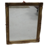 A 20th century wall mirror - the bevelled plate within a swept frame with leaf moulded corners,