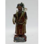 A late 19th century Chinese figure of a scholar - with treacle glazes, the figure standing on a