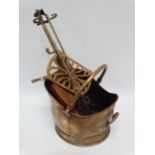 A late 19th century brass poker - together with a similar pair of tongs, helmet shaped coal scuttle,