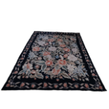 A large 20th century Aubusson rug - decorated with roses on a black ground within a budding