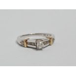 A diamond ring - the central round cut stone claw set in 14ct white gold with diamond set shoulders,
