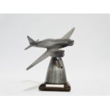 A polished aluminium desk paperweight - modelled as a De Havilland .88 Comet mounted on a tapering