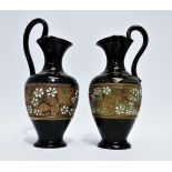 A matched pair of Doulton Lambeth jugs - with sgraffito foliate decoration, the base marked with