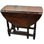 A 17th century and later oak drop leaf table - the oval top on square and turned legs joined by