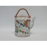 A Chinese late 19th century teapot - polychrome decorated with flowers, twin cane swing handle,