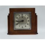 An oak cased Art Deco style mantel clock - the silvered square dial set out with Arabic numerals