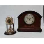 An Edwardian mahogany mantle clock - the case with foliate inlay and brass columns, the dial set out