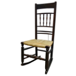An 18th century ash rocking chair - with a bobbin turned back and rush seat, the legs joined by