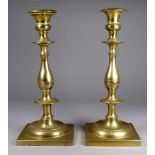 A pair of 19th century brass candlesticks - of baluster form on a square base, height 24cm
