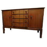 A Gordon Russell oak sideboard - with an arrangement of four drawers flanked by cupboards on