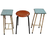 A pair of mid 20th century kitchen stools - the square seats upholstered in a fabric in the manner
