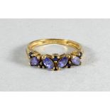 A 9ct gold ring - set with purple hardstones, size N, weight 2.1g.