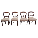 A set of four Victorian mahogany balloon back chairs - the overstuffed upholstered seats on turned