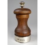 A wooden pepper grinder with a silver cuff - London 1969, height 10cm.