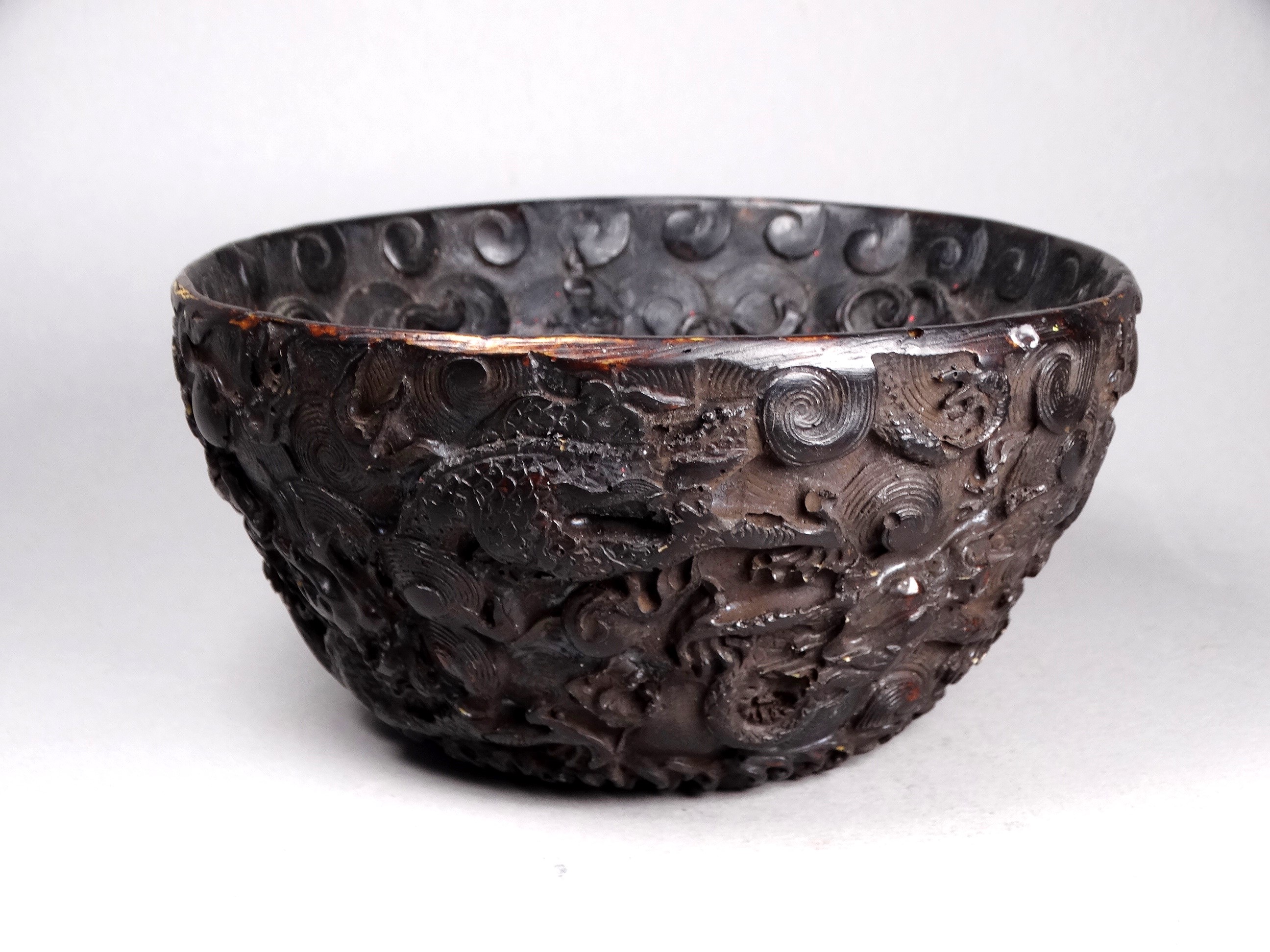 A Chinese bowl - the relief decoration showing dragons chasing a flaming pearl, diam. 15cm