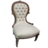 A late Victorian button upholstered spoon back chair - the walnut frame with cream cotton
