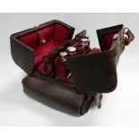 A leather Gladstone style bag - fitted with dressing items including glass bottles with silver tops,