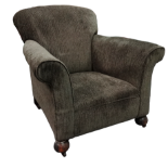 An early 20th century club armchair - upholstered in sage green fabric and raised on ball feet