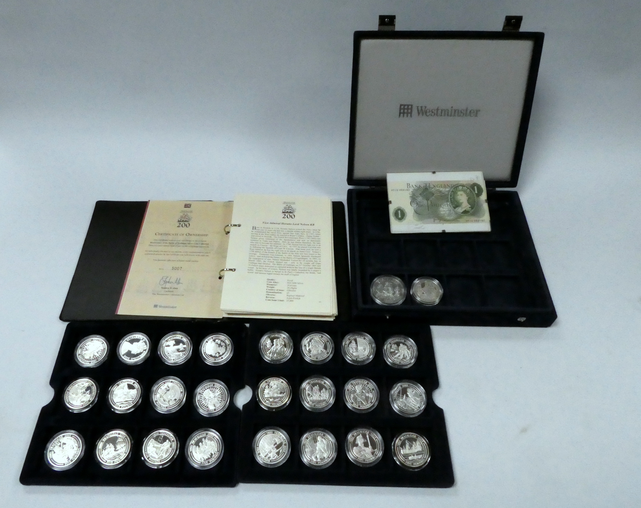 Twenty six silver bullion commemorative Trafalgar crowns - together with a one pound note.
