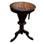 A Victorian walnut games and work table - the circular hinged top enclosing a fitted interior and