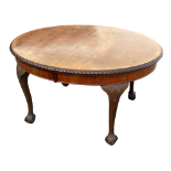 A George II style walnut extending dining table - the oval top with gadrooned border and raised on