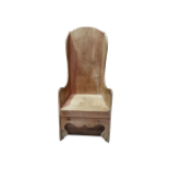 A late 19th century pine rocking wing armchair - the seat above an ogee shaped apron, height 130cm.