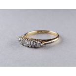 A five stone diamond ring - with a foliate scroll setting on an 18ct yellow gold band, ring size
