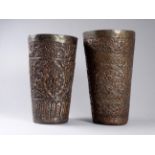 Two Persian metalware beakers - repousse decorated with flowers, largest height 16cm.