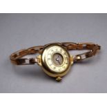 An early 20th century 18ct yellow gold ladies wristwatch - the cream dial set out in Arabic numerals