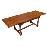 An oak draw-leaf table - the cleated plank top above square and turned legs joined by a central