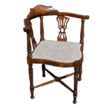 An Edwardian mahogany corner armchair - the back inlaid with flowers above pierced splats on