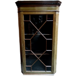 An Edwardian mahogany corner cupboard - the dentil moulded cornice above an astragal door